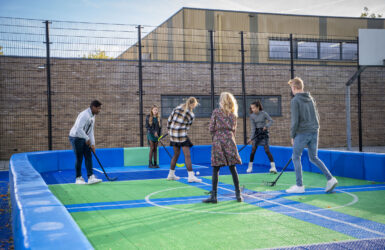 Leerlingen spelen hockey in het hockeyveld op locatie Middelburg van het Calvijn College