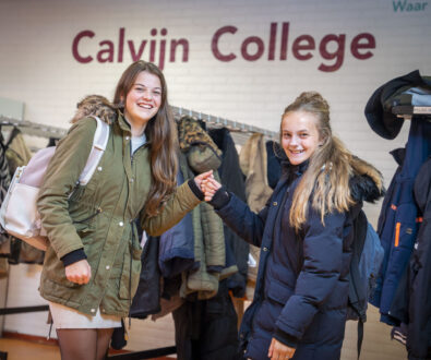 Leerlingen geven elkaar een boks in de gang van het Calvijn College Tholen