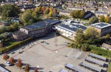 Dronefoto locatie Krabbendijke Appelstraat, het plein, de fietsenhokken en zonnepanelen zijn te zien