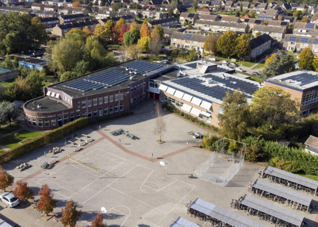 Dronefoto locatie Krabbendijke Appelstraat, het plein, de fietsenhokken en zonnepanelen zijn te zien