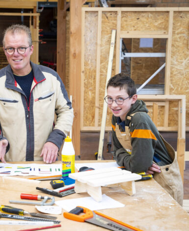 Docent en leerling van de afdeling bouwen, wonen en interieur zijn samen bezig aan een project