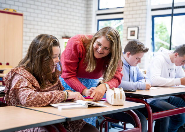 Docent geeft uitleg aan leerling