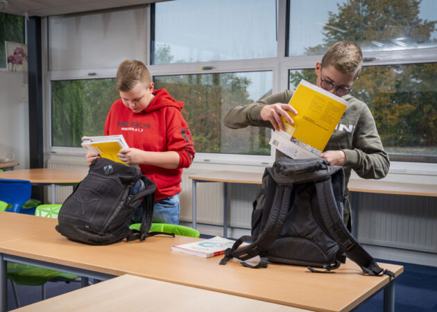 Twee jongens pakken hun tas in met boeken op het Calvijn College, locatie Goes Noordhoeklaan