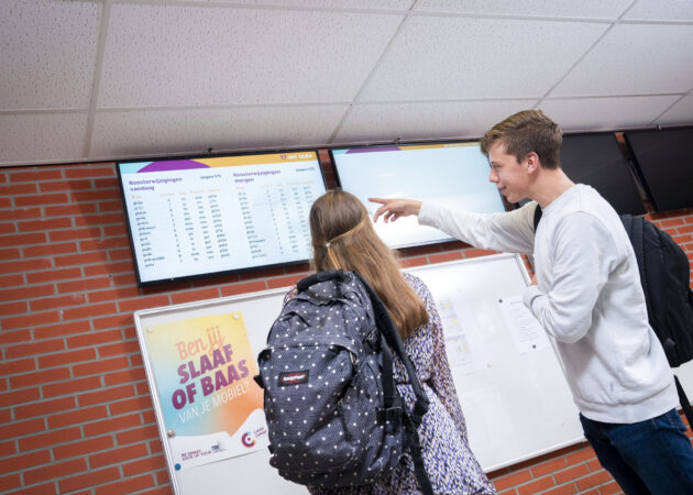 Leerlingen kijken naar het rooster op het roosterbord