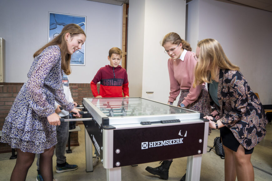 Leerlingen spelen een potje tafelvoetbal.