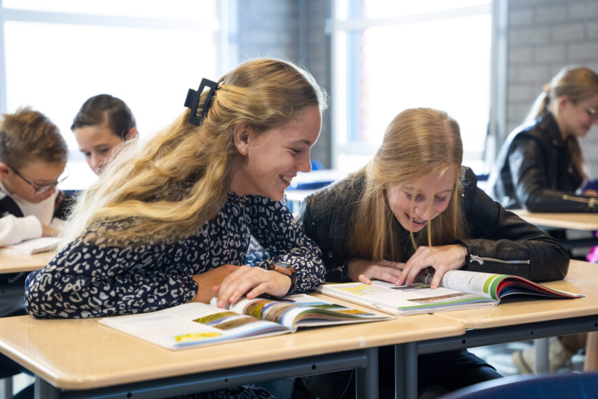 Leerlingen op het vmbo van locatie Goes Stationspark kijken bij elkaar in een boek