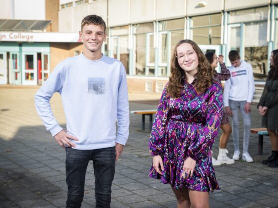 Twee leerlingen van locatie Krabbendijke Kerkpolder staan op het plein en lachen in de camera