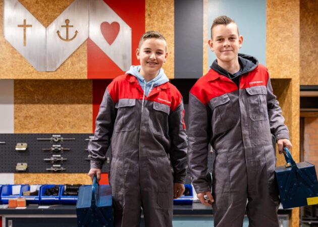 Leerlingen op werkplaats, metaal bord geloof, hoop , liefde
