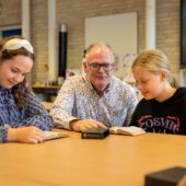 Leerling en docent lezen samen uit Bijbel