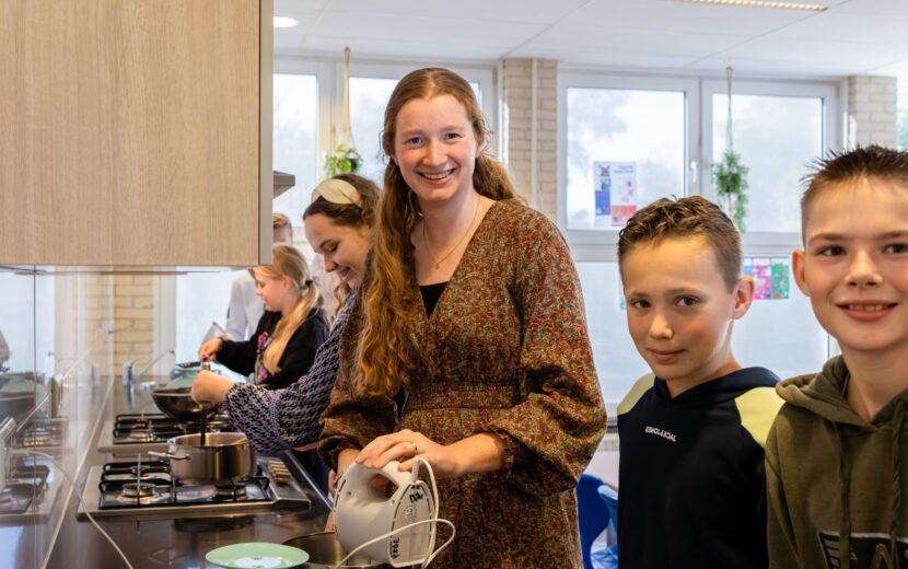 Onderwijsassistent met leerlingen tijdens kookles