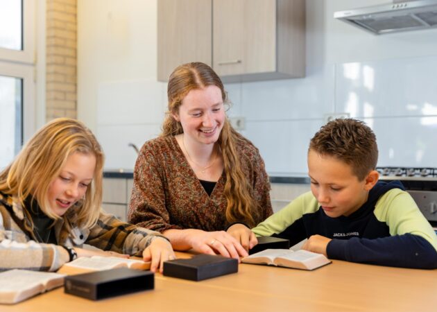Leerlingen, onderwijsassistent, samen Bijbel lezen