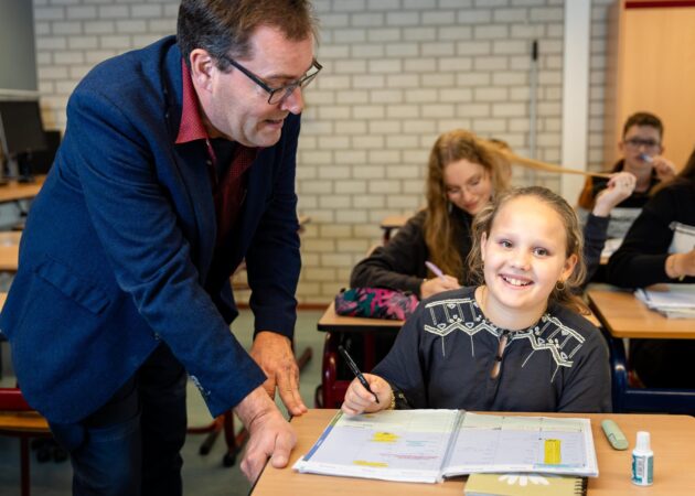Leraar geeft uitleg aan leerling tijdens les