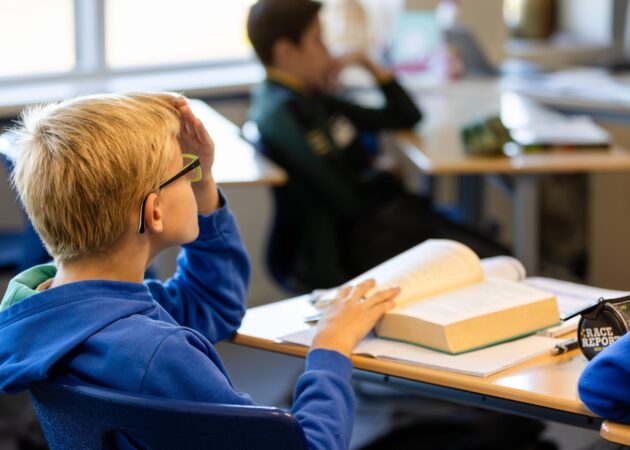 Leerling met boek in de klas